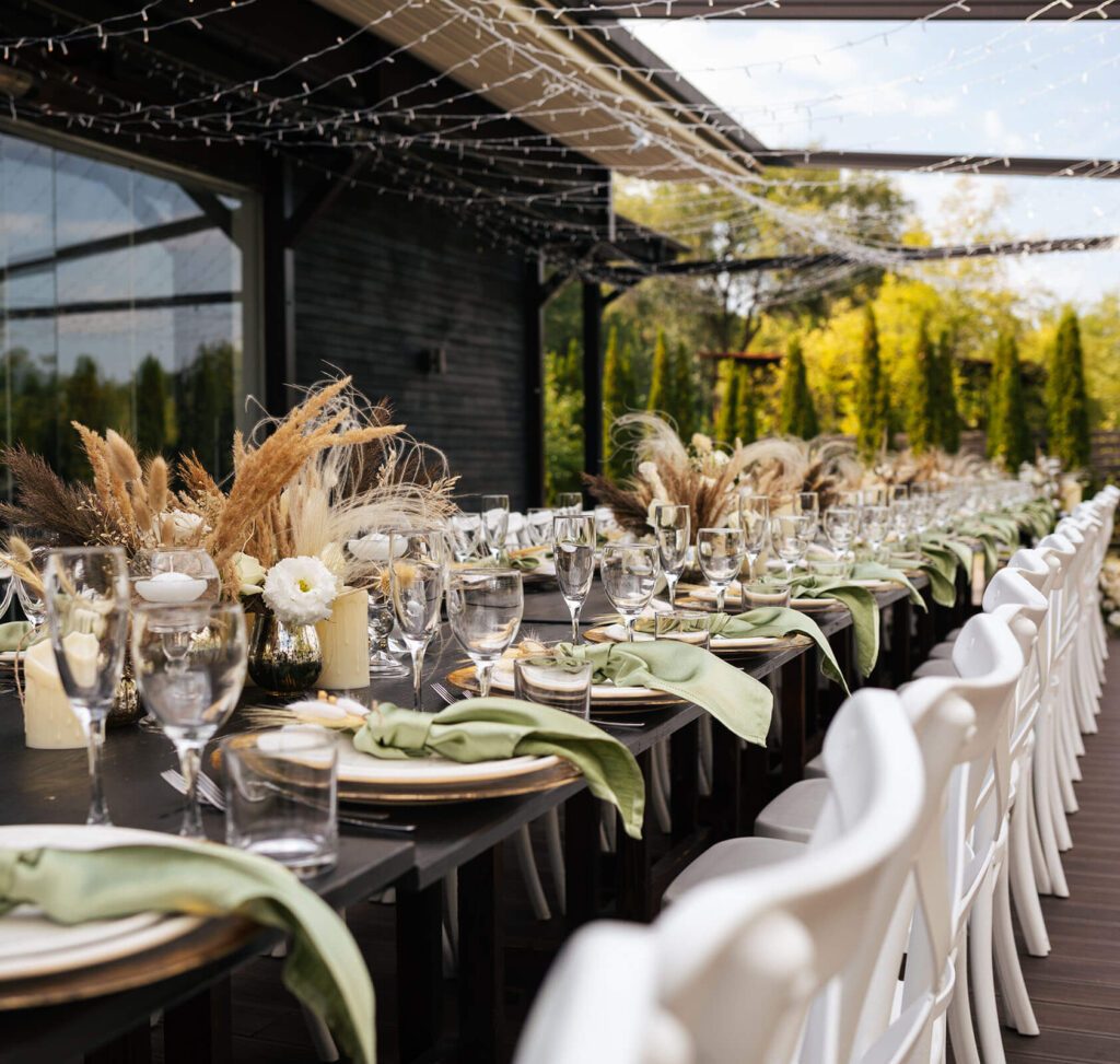 gedeckter Tisch, unter Lichterketten an der frischen Luft